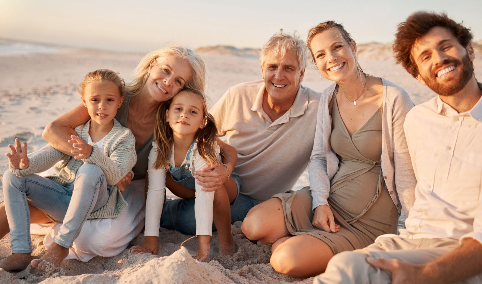 Three generations of a family together on the beach at sunset